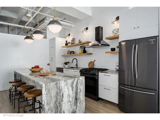 a kitchen with stainless steel appliances granite countertop a refrigerator and a stove