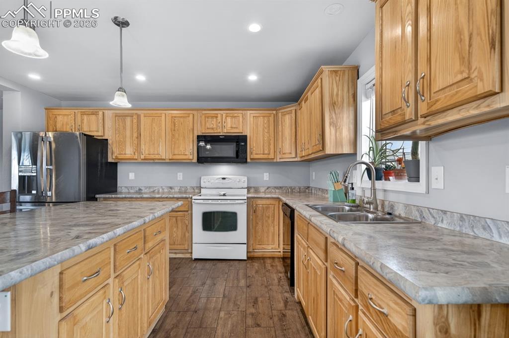 736 Indiana Avenue Limon, CO 80828 - Photo 13 of 37 a kitchen with stainless steel appliances granite countertop a sink stove and refrigerator