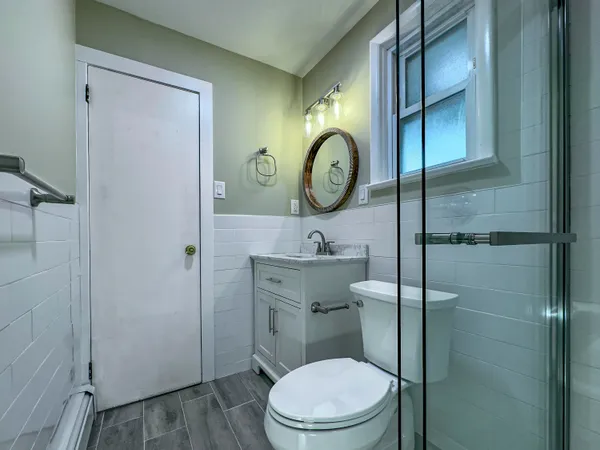 a bathroom with a toilet a sink and mirror