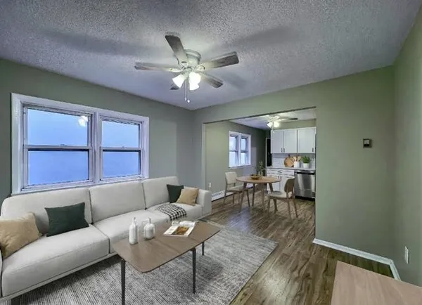 a living room with furniture wooden floor and a window