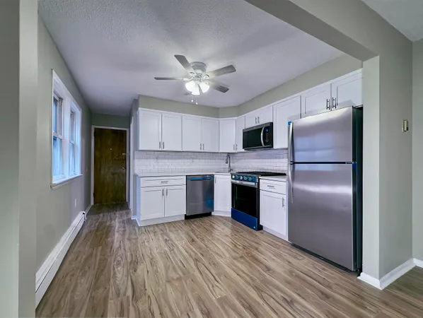 a kitchen with a refrigerator and a stove top oven