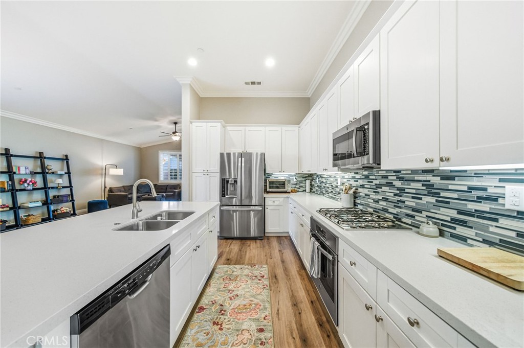 26535 Rim Creek Path Menifee, CA 92584 - Photo 11 of 50 a kitchen with stainless steel appliances a sink stove and cabinets