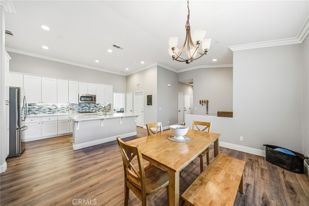 26535 Rim Creek Path Menifee, CA 92584 - Photo 17 of 50 a view of a dining room with furniture a chandelier and wooden floor