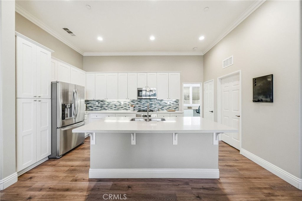 26535 Rim Creek Path Menifee, CA 92584 - Photo 9 of 50 a view of a kitchen with wooden floor and stainless steel appliances