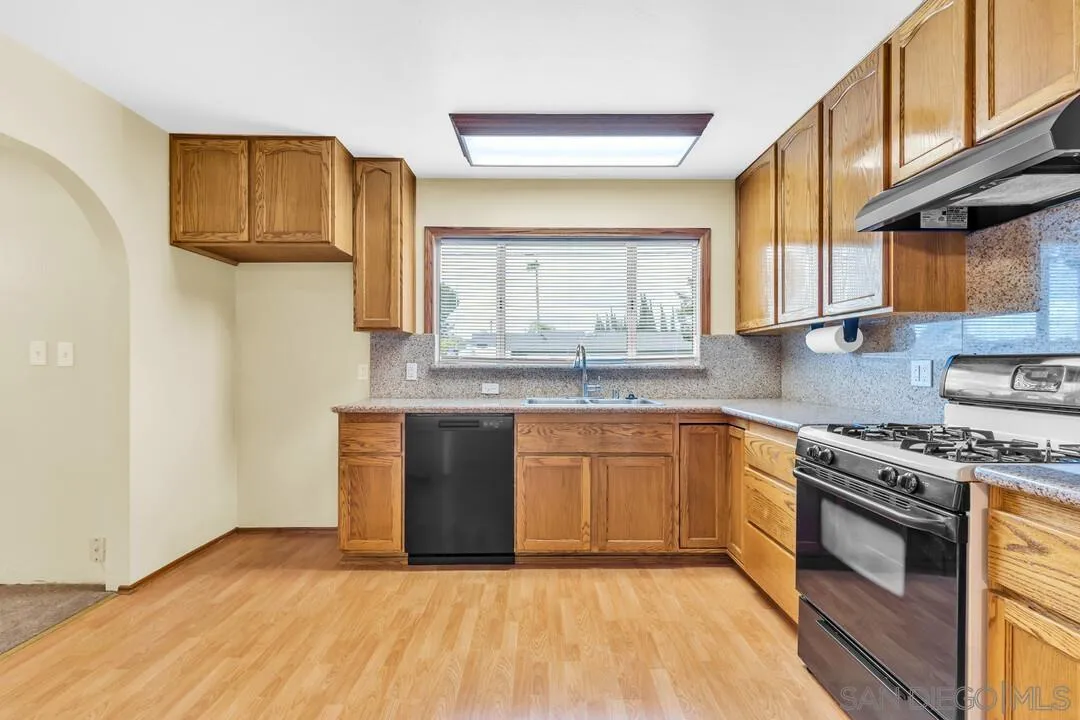 9540 Abbeyfield Road Santee, CA 92071 - Photo 10 of 35 a kitchen with granite countertop a sink cabinets stainless steel appliances and a window