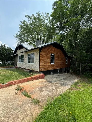 a backyard of a house with wooden fence and large trees
