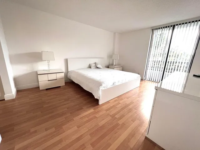 a spacious bedroom with a bed and a large window