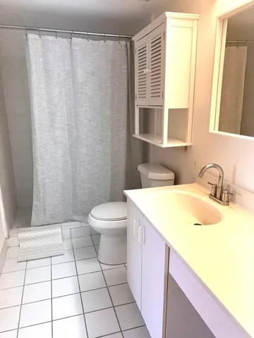 a bath room with a sink a toilet and a shower