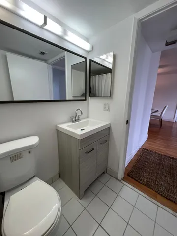a bathroom with a sink toilet and mirror