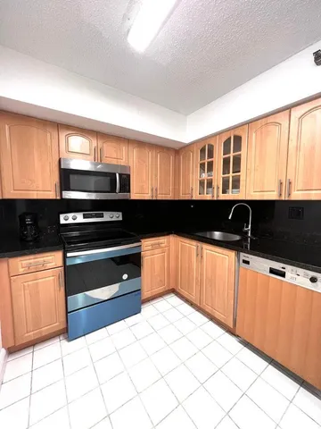 a kitchen with granite countertop a stove and a sink