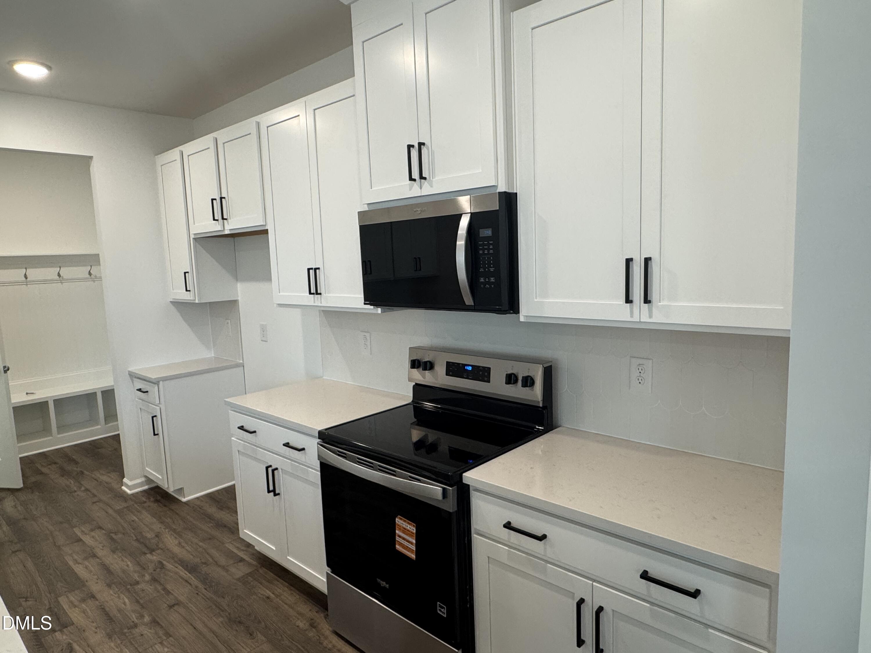 128 Vulcan Street Garner, NC 27529 - Photo 7 of 28 a kitchen with stainless steel appliances a stove a microwave and cabinets