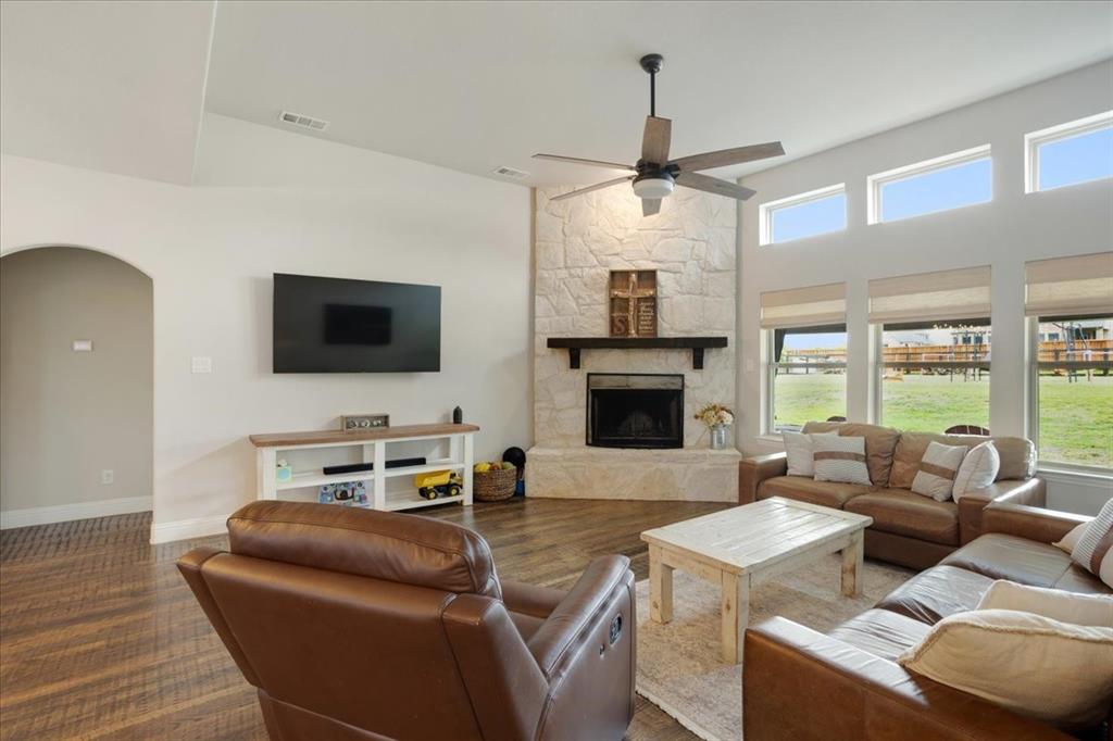 1205 Redbud Street Howe, TX 75459 - Photo 5 of 40 a living room with furniture a fireplace and a flat screen tv