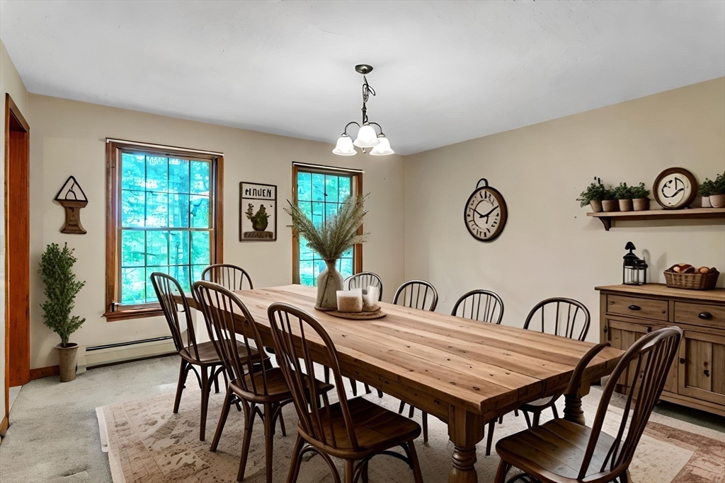 17 Church Road Huntington, MA 01050 - Photo 14 of 36 a dining room with wooden floor a chandelier a wooden table and chairs