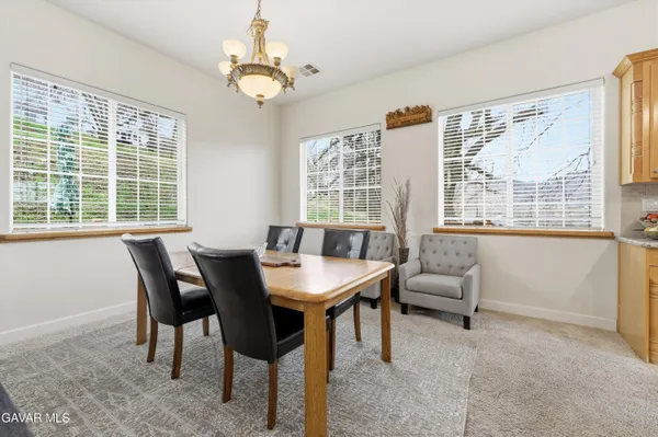 a view of a dining room with furniture a chandelier and wooden floor
