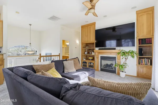 a living room with furniture kitchen view and a chandelier