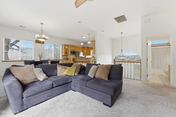 a kitchen with stainless steel appliances a sink a stove a refrigerator cabinets and a window