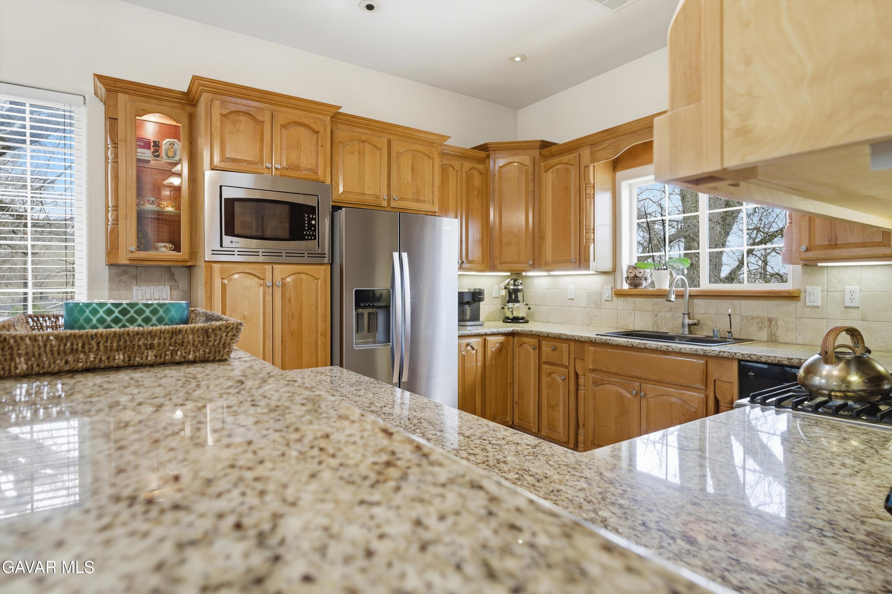 20000 Brite Valley Road Tehachapi, CA 93561 - Photo 26 of 32 a kitchen with stainless steel appliances a sink a stove a refrigerator cabinets and a window