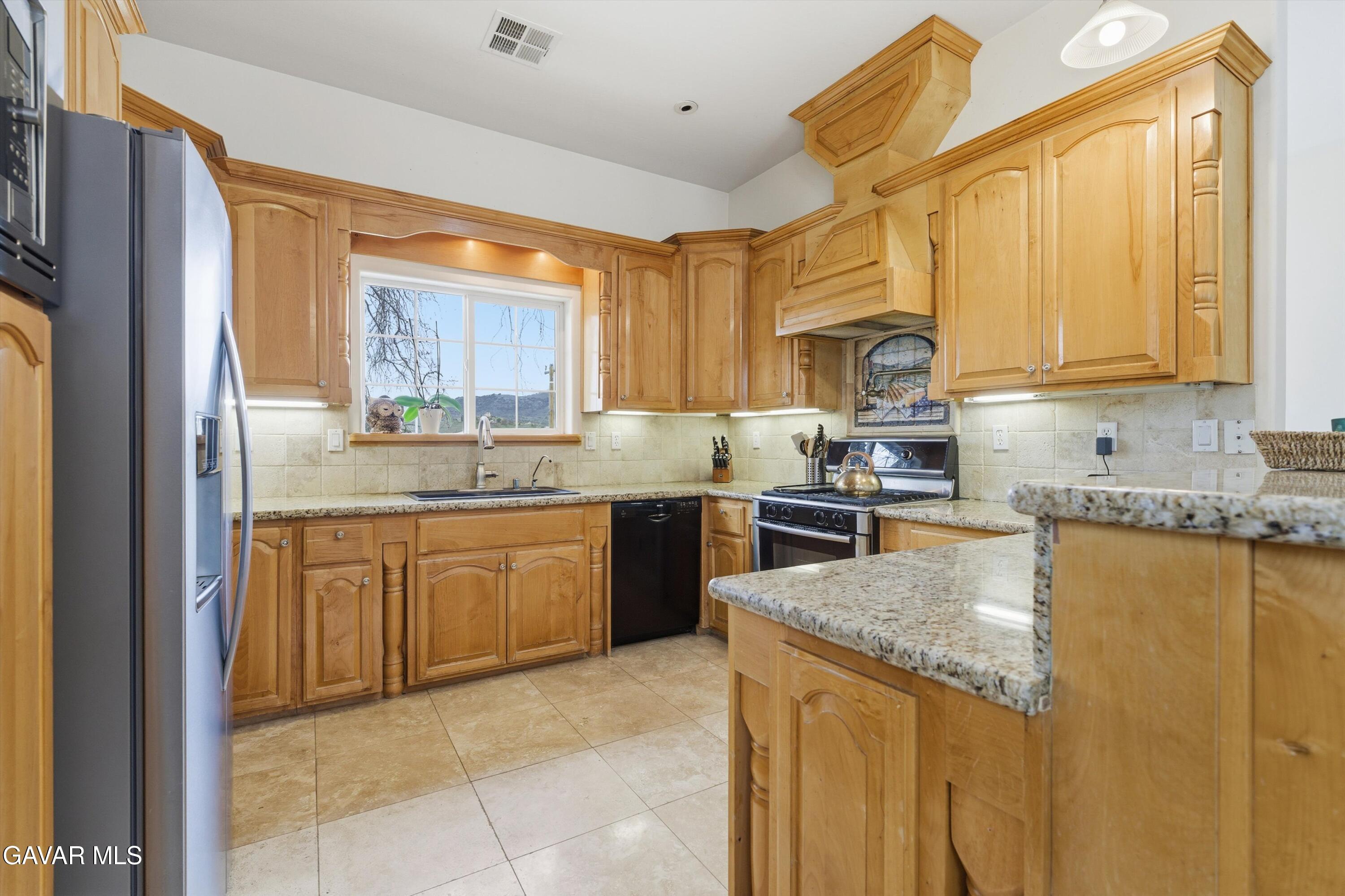 20000 Brite Valley Road Tehachapi, CA 93561 - Photo 28 of 32 a kitchen with a refrigerator a stove top oven a sink and dishwasher with wooden floor