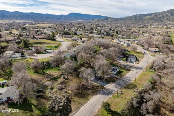 an aerial view of residential house with yard and mountain view