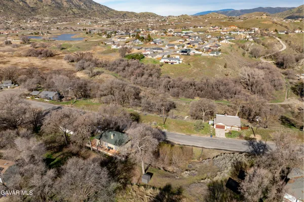 an aerial view of residential house with yard and mountain view