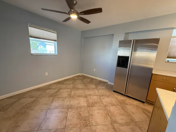 a view of an empty room and a kitchen