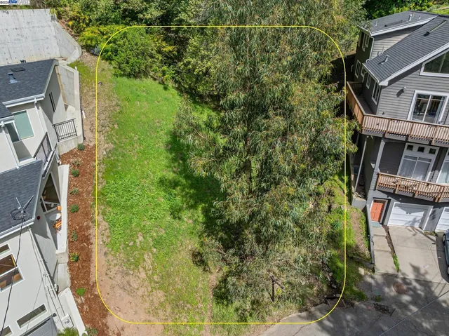 an aerial view of residential houses with outdoor space and trees