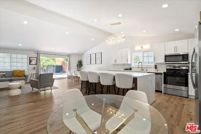 a large kitchen with kitchen island a stove a sink a dining table and chairs