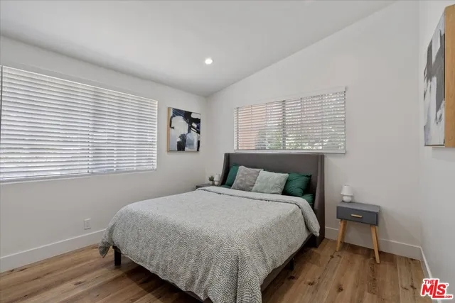 a bedroom with a bed two lamps and a window