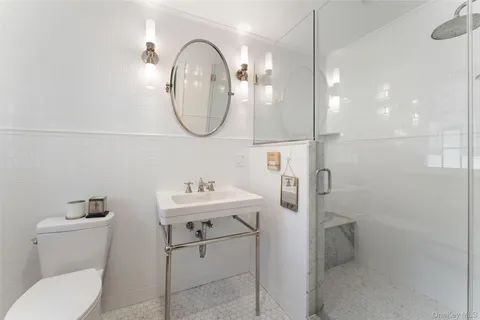 a bathroom with a toilet sink and mirror