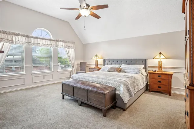 a spacious bedroom with a bed and a chandelier