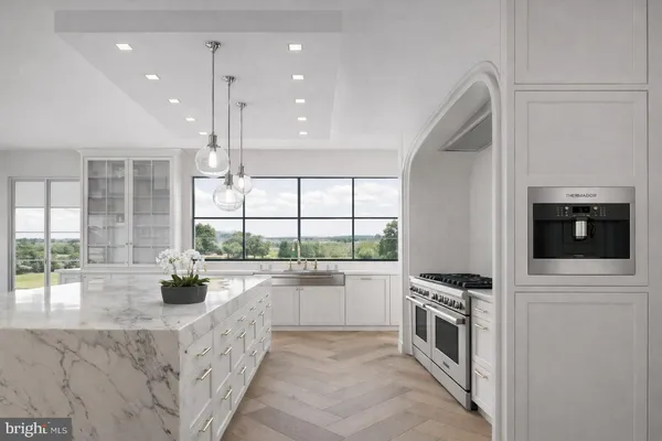 a large kitchen with stainless steel appliances a stove a sink and a refrigerator