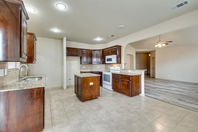 a kitchen with stainless steel appliances granite countertop a sink and a stove