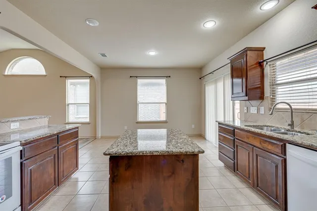 a large kitchen with stainless steel appliances granite countertop a stove a sink and a granite counter tops