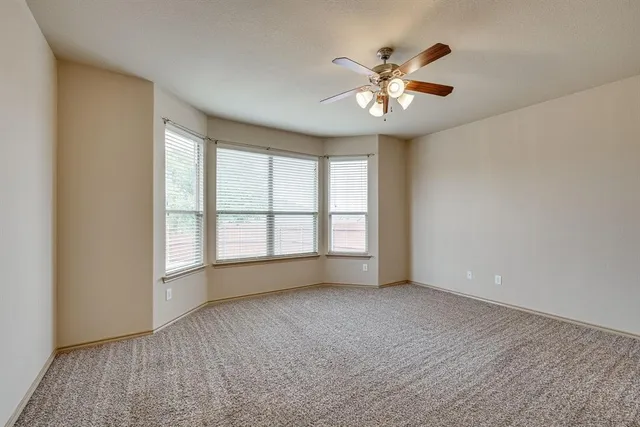 an empty room with closet and a ceiling fan