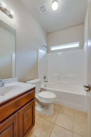 an empty room with a chandelier fan and windows