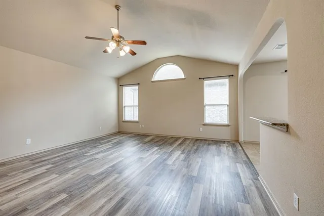 a view of empty room with fireplace and wooden floor