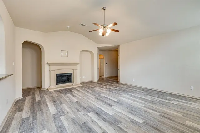 a living room with a fireplace and wooden floor