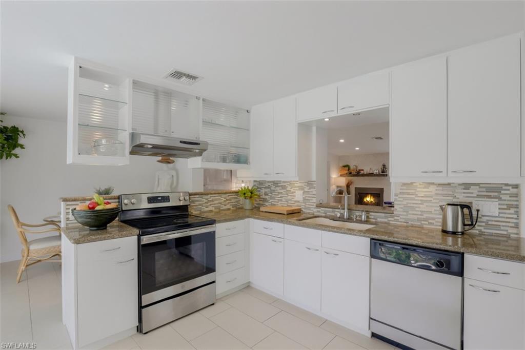 6640 Trail Boulevard Naples, FL 34108 - Photo 11 of 25 a kitchen with stainless steel appliances a stove a sink and white cabinets