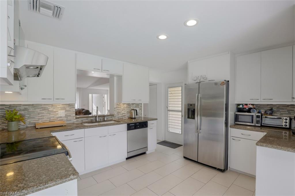 6640 Trail Boulevard Naples, FL 34108 - Photo 13 of 25 a kitchen with stainless steel appliances a refrigerator sink and stove