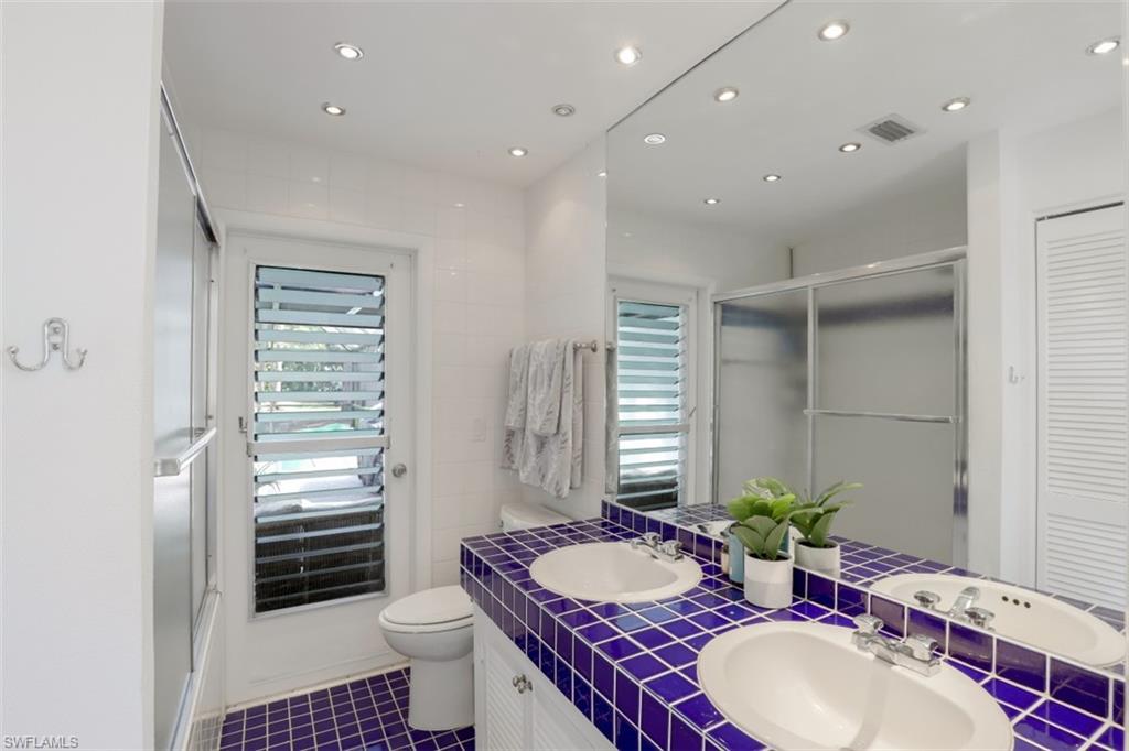 6640 Trail Boulevard Naples, FL 34108 - Photo 15 of 25 a spacious bathroom with a granite countertop sink a toilet a mirror and shower