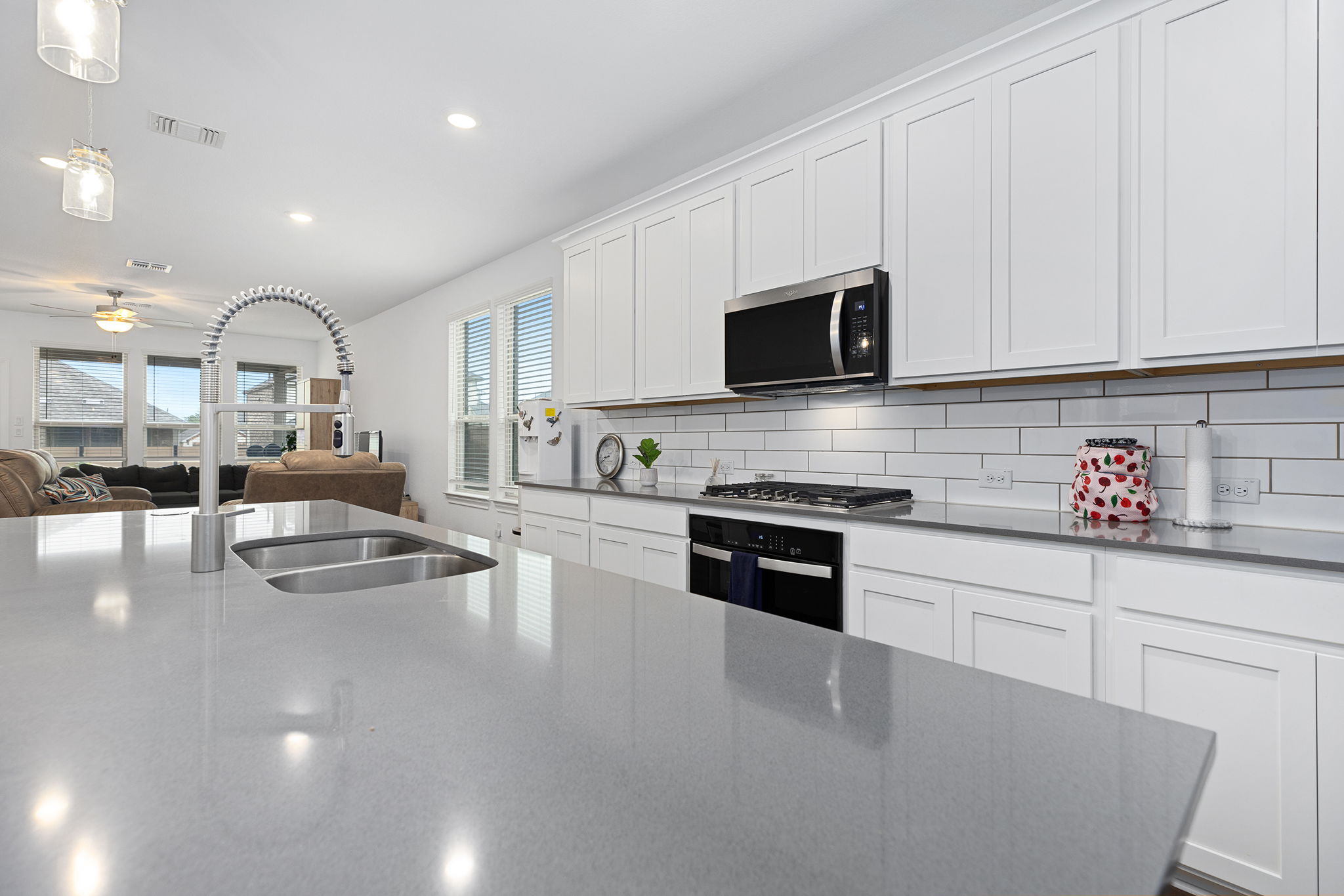 116 Raleigh Drive Georgetown, TX 78633 - Photo 6 of 28 A streamlined kitchen island with integrated sink overlooks an inviting living space, perfect for entertaining.