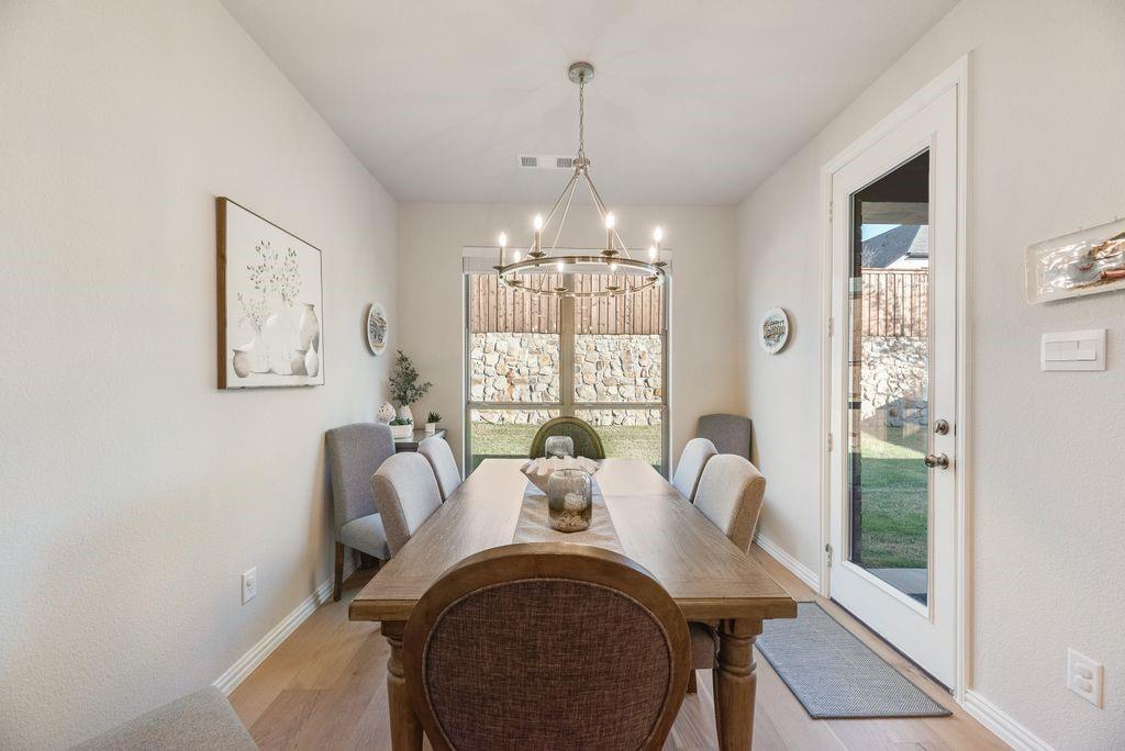 227 Buffalo Boulevard Rhome, TX 76078 - Photo 11 of 39 a view of a dining room with furniture wooden floor and a chandelier