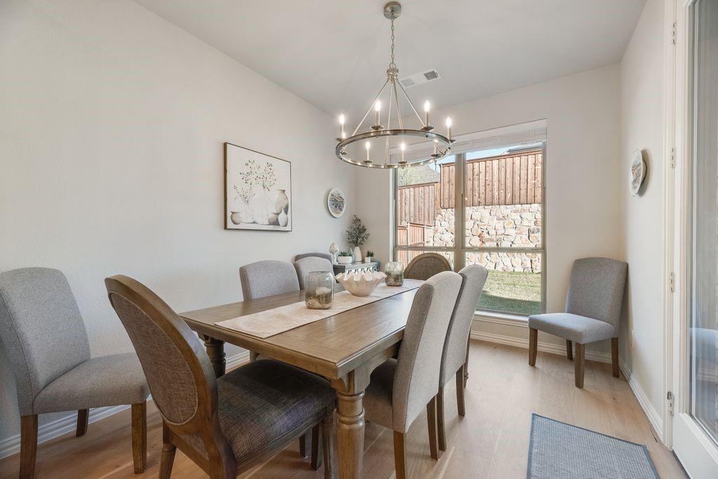 227 Buffalo Boulevard Rhome, TX 76078 - Photo 12 of 39 a view of a dining room with furniture a chandelier and wooden floor