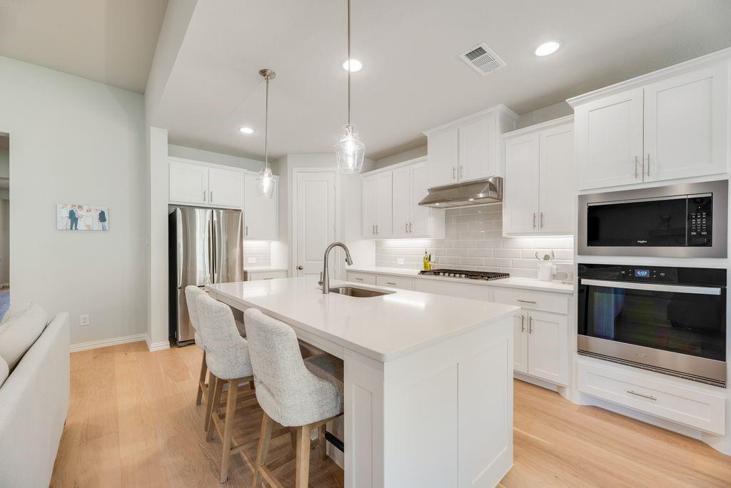 227 Buffalo Boulevard Rhome, TX 76078 - Photo 13 of 39 a kitchen with stainless steel appliances a stove a sink a refrigerator and a oven