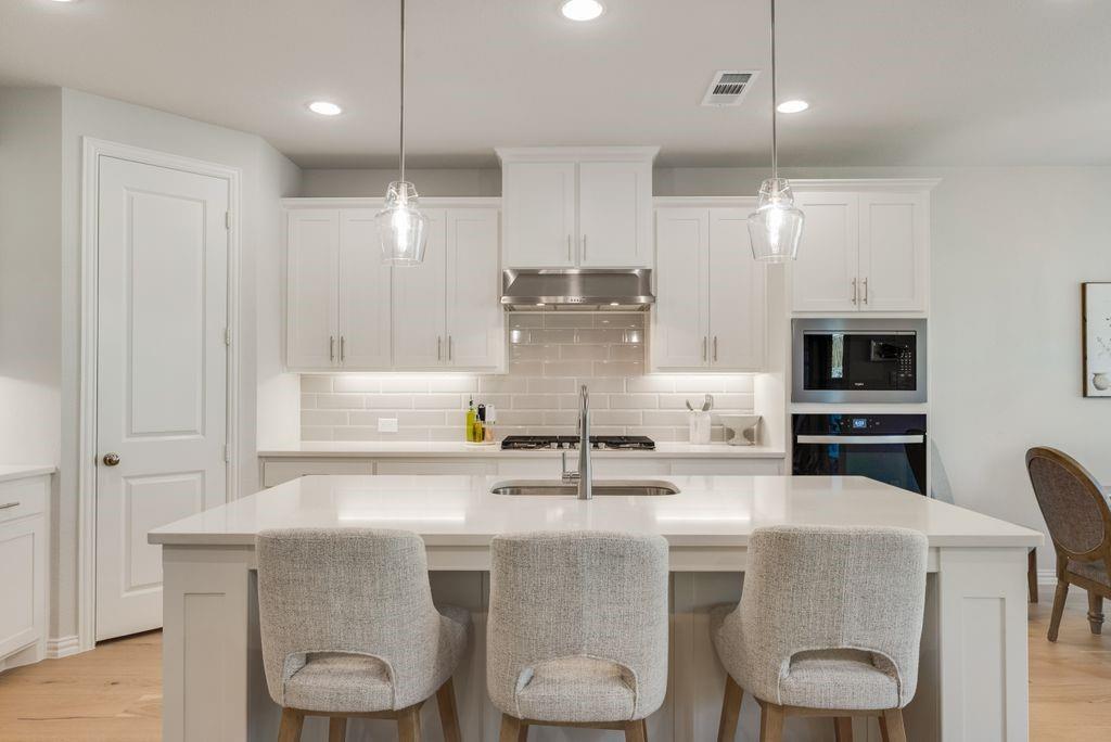 227 Buffalo Boulevard Rhome, TX 76078 - Photo 14 of 39 a kitchen with stainless steel appliances a dining table and chairs
