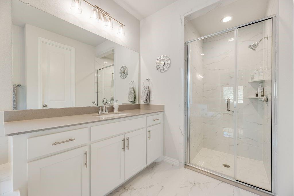 227 Buffalo Boulevard Rhome, TX 76078 - Photo 20 of 39 a bathroom with a shower sink and mirror