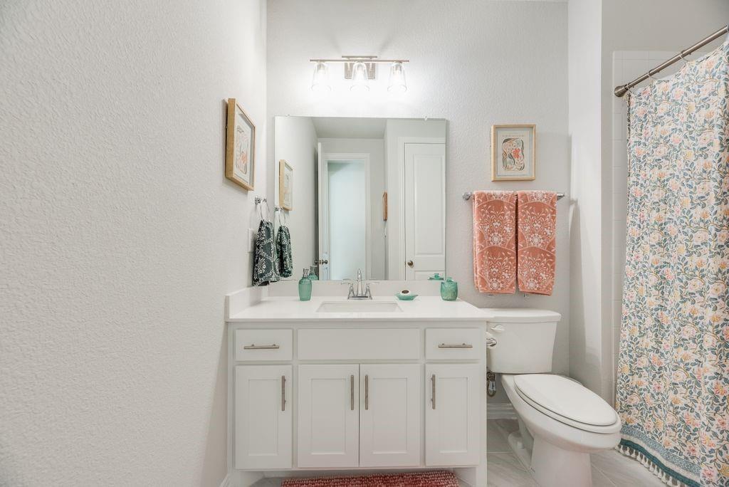 227 Buffalo Boulevard Rhome, TX 76078 - Photo 27 of 39 a bathroom with a sink a toilet and mirror