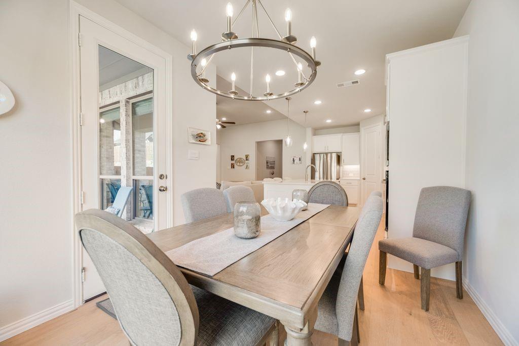 227 Buffalo Boulevard Rhome, TX 76078 - Photo 10 of 39 a dining room with furniture a mirror and wooden floor