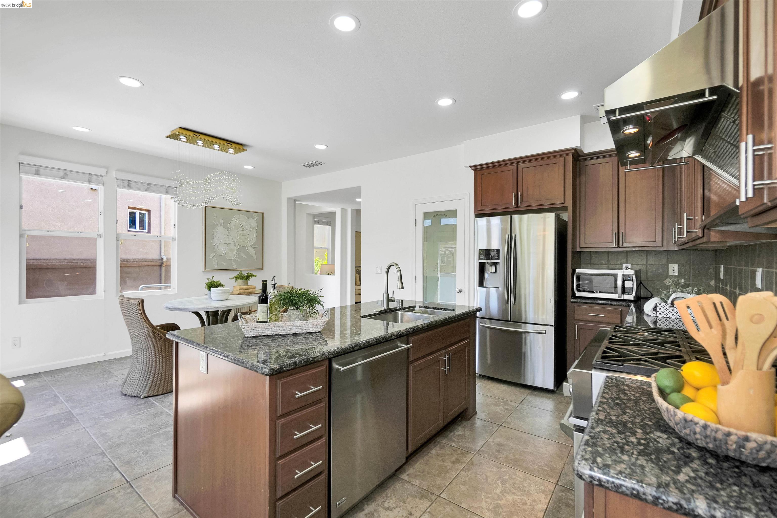 449 Constantine Court San Ramon, CA 94583 - Photo 27 of 63 Gourmet kitchen featuring a large central island with a stainless steel sink, granite countertops, stainless steel appliances, recessed lighting, and rich wood cabinetry