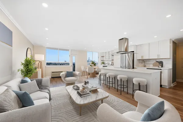 a living room with furniture kitchen view and a window